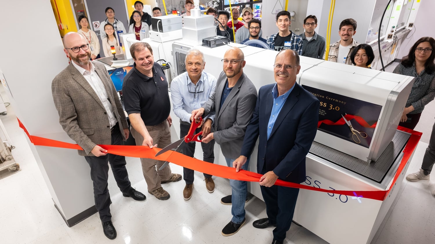 Lex Kemper, associate dean for research at the College of Sciences, cuts a ribbon at the inauguration ceremony for the Xeuss 3.0 instrument